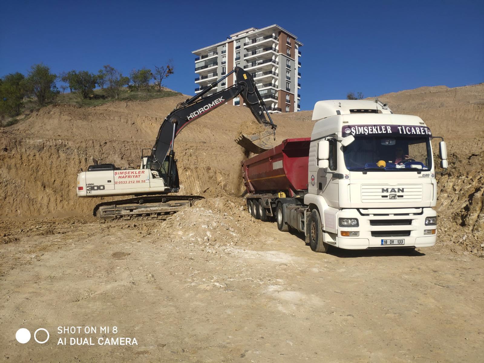 Şimşekler Hafriyat ekskavatörü sahada bir damperli kamyona yükleme yapıyor.